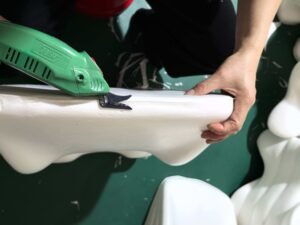Artisan hand-trimming the edge of a luxury private label pillow in DOWCHI's boutique workshop