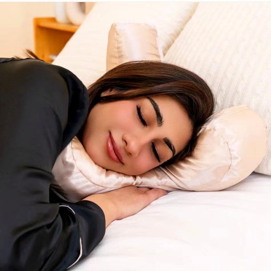 Woman side-sleeping on the champagne satin anti-wrinkle face pillow, jaw supported by the contour